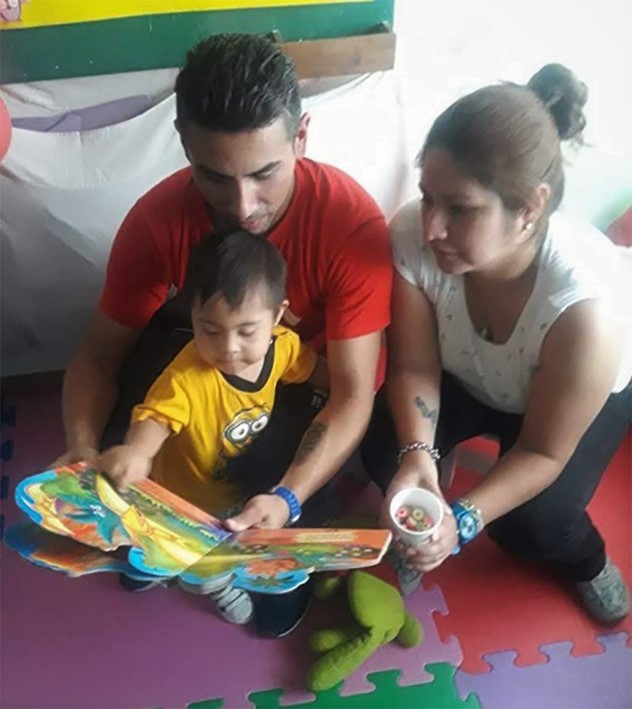 Photo of Padres que leen un libro a sus hijos en la Bebeteca
